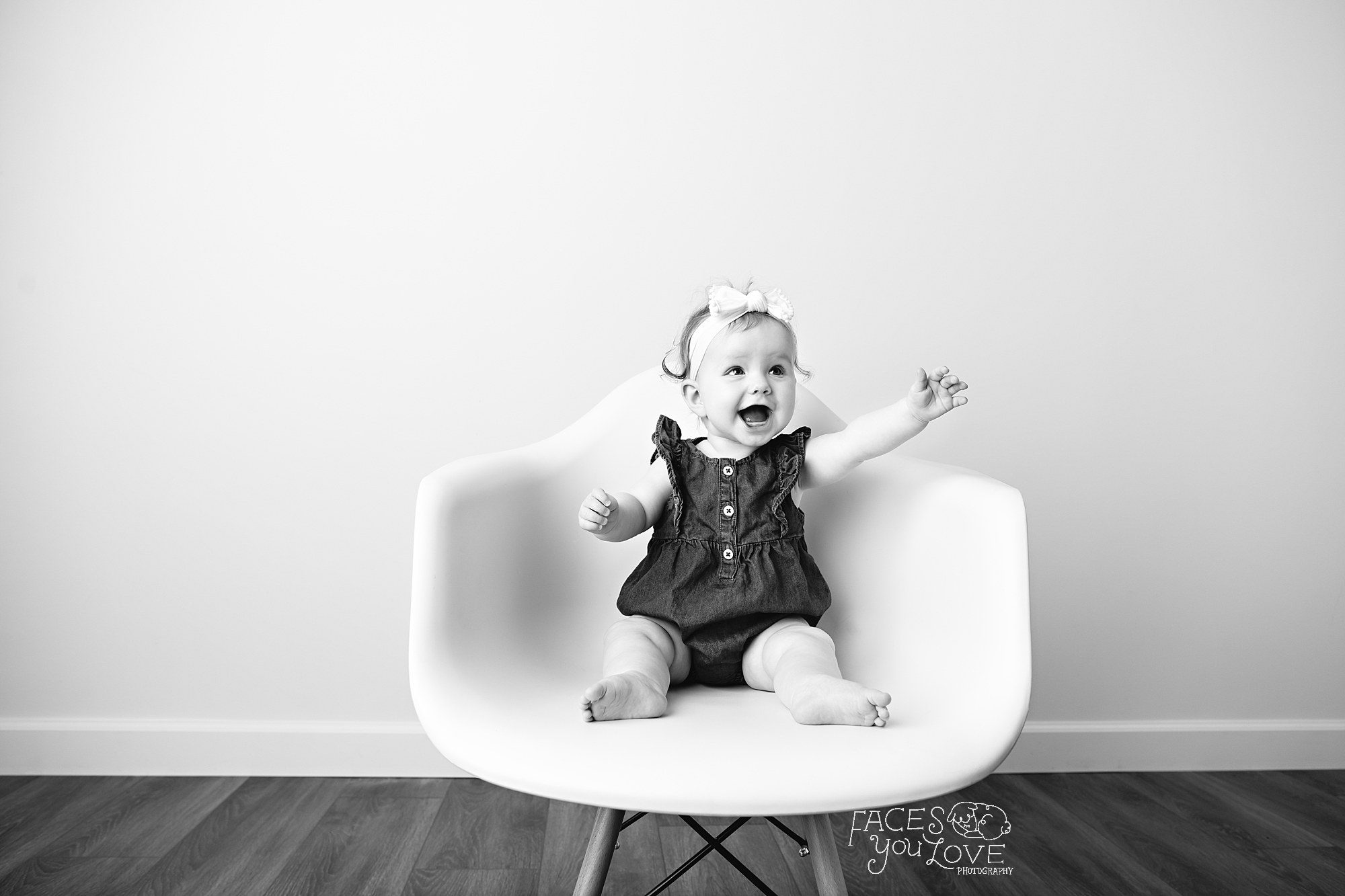 black and white of baby girl reaching out, modern chair, portrait photographer kansas city