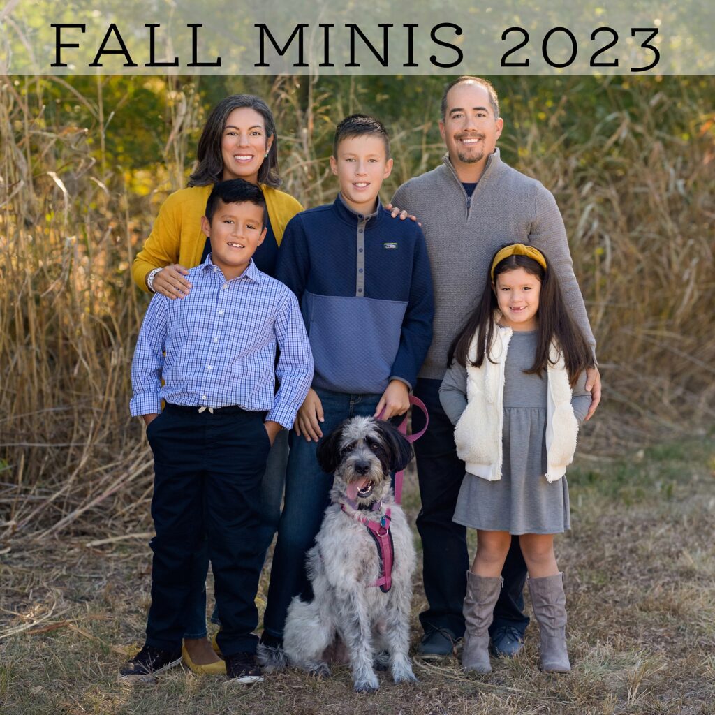 Kansas City family at a fall mini session, held last year in Overland Park by Faces You Love Photography. They're wearing a mix of blues, grays, and yellow, and their dog is posing with them 